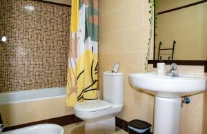 a bathroom with a toilet and a sink at Apartamento amplio con gran terraza y vistas in Monachil +20 photos