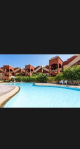 ein großes Schwimmbad vor einem Gebäude in der Unterkunft Bungalows village Town house T3 in Dawwār Abū Duray‘ah ‘Abd al Karīm
