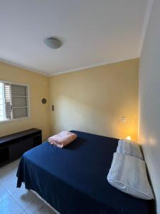 a bedroom with a blue bed with a blue blanket at Kasa Kaya in Araraquara