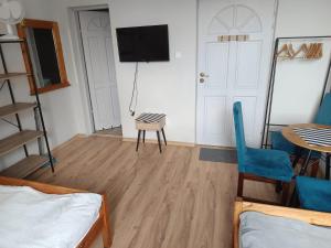 a room with a tv and a table and chairs at 117 in Łeba