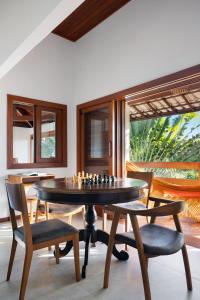 a dining room with a table with chessetts on it at Casa Beija Flor - Taipu de fora - Marau in Marau
