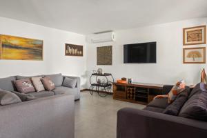a living room with two couches and a tv at Casa Beija Flor - Taipu de fora - Marau in Marau