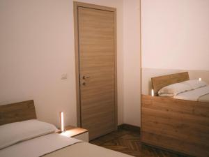 a bedroom with two beds and a door with two candles at Appartamenti Rivo Gelassa in Susa +3 photos