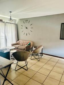 een woonkamer met een bank en een klok aan de muur bij 2 Spacious bedroom apartment in Lephalale