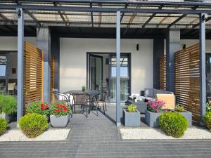 patio ze stołem, krzesłami i roślinami w obiekcie Polna Sarbinowo w Sarbinowie