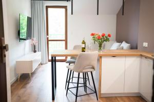 une cuisine avec une table et des chaises dans une pièce dans l'établissement Willa Matejki - Apartament 8a, à Przemyśl