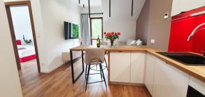 une cuisine avec un comptoir et un bar avec une chaise dans l'établissement Willa Matejki - Apartament 8a, à Przemyśl 5 autres photos