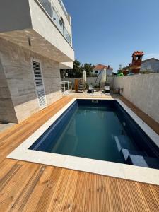 a swimming pool on the deck of a house at Villa Regina Apartment Carlito with swimming pool in Jezera
