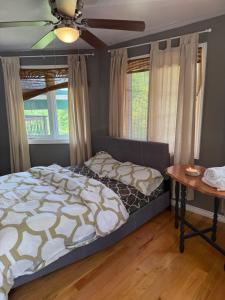 ein Schlafzimmer mit einem Bett und einem Tisch und Fenstern in der Unterkunft Bear Lake Cottage in Mountain Grove