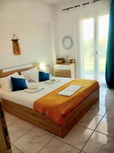 a bedroom with a large bed with blue pillows at 4T apartments in Argostoli