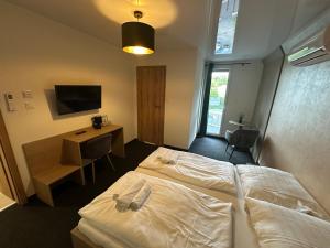 a bedroom with a bed and a desk and a television at Cliff House & Restaurant in Żary