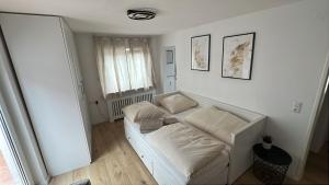 Sofá blanco en una habitación con ventana en Apartment Tas, en Rottendorf