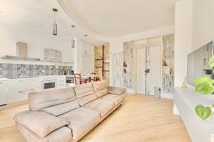 Una sala de estar con un sofá y una cocina. en Blanc72, en Turín