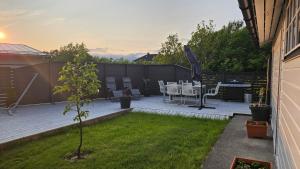 a small garden with a table and chairs on a patio at Cozy and warm just like at home, Free P, Big terrace in Langevåg