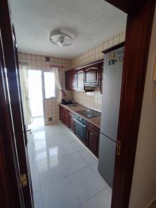a kitchen with wooden cabinets and a white refrigerator at Casa Zenn in Puerto del Rosario +3 photos