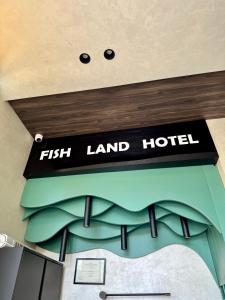 a sign for a fish land hotel in a room at FishLand Seaside Apartments in Durrës