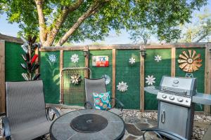 a patio with a table and chairs and a grill at 1929 Wash House in Fredericksburg