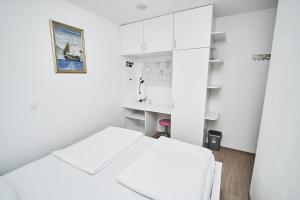 een witte kamer met een bed en een bureau bij Matic Murgle Atrium Apartment in Ljubljana