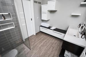 een witte badkamer met douche en wastafel bij Matic Murgle Atrium Apartment in Ljubljana +18 foto's