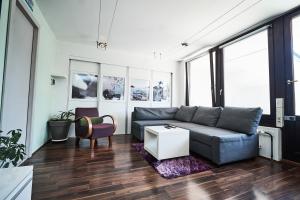 een woonkamer met een bank en een tafel bij Matic Murgle Atrium Apartment in Ljubljana