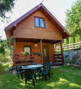 a cabin with a table and chairs in the yard at Spokojna 10 Dom Wakacyjny w Ogrodzie in Polańczyk
