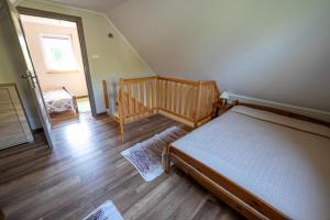 a bedroom with a bed and a wooden floor at Spokojna 10 Dom Wakacyjny w Ogrodzie in Polańczyk