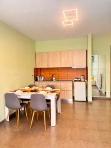 a kitchen with a table and chairs and a refrigerator at Greywood Nest in Alexandroupoli