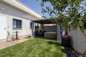a backyard with a covered patio with a couch and a table at צימר נחלים - בקיבוץ הגושרים in Hagoshrim