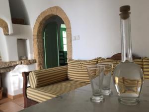 a table with two glass vases on a table with a couch at Villa Lemonia - Guest House in Aroniadika