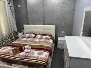 a small bedroom with a bed with a headboard at Luxe Apartment Gjiri Lalzit in Lalzit Bay