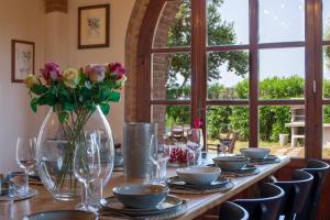a long table with glasses and flowers on it at Villa Leone Reale in Collemezzano