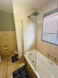 een badkamer met douche en ligbad bij 2 Spacious bedroom apartment in Lephalale