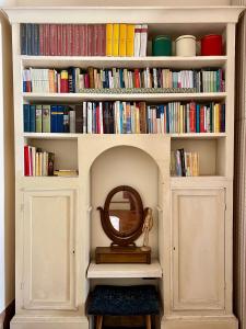 ein Bücherregal gefüllt mit Büchern und einem Spiegel in der Unterkunft Ca Fosca in Bologna
