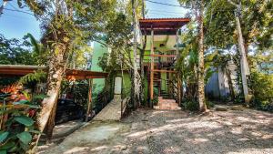a house with a staircase in the middle of trees at Chalés Ubatuba do Alto in Ubatuba