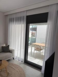 ニキティにあるEvion Apartments in Nikiti A13のソファとガラスの引き戸のあるリビングルーム +11枚の写真