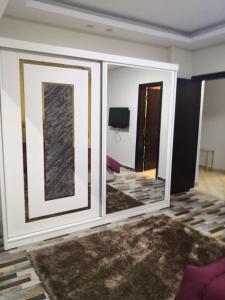 a living room with a large mirror in a room at Alhejaz Luxurious Apartment in Cairo