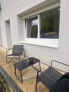 two chairs and a table in front of a window at Maison de village in Lavigny