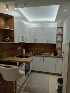 Una cocina con gabinetes blancos y un fregadero. en Apartman Gold King, en Brčko 10 fotos más