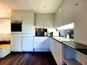 una cocina con armarios blancos y electrodomésticos blancos en Luxurious Mansion in Robertville near Forest en Robertville