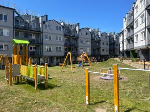 a playground in front of a apartment complex at Apartamenty Modrzewiowa Enklawa in Debina