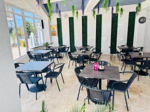 a restaurant with tables and chairs in a room at HOTEL KM 0 in Costinesti