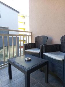 a patio with two chairs and a table and a balcony at Apartman Gold King in Brčko