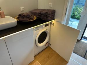 a kitchen with a washing machine under a counter at Premium Chalet A in Ebenzweier