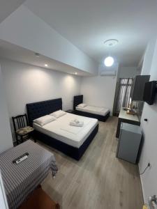 a small room with two beds and a table at Hotel Villa Flowers 2 in Vlorë