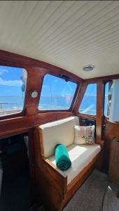 Un asiento en la parte trasera de un barco con tres ventanas. en SISU 1 - Boat House, en Olhão