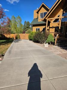 a shadow of a person walking down a driveway at Tree House Pinetop Az in Pinetop-Lakeside