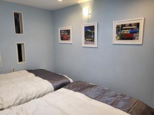 a bedroom with two beds and pictures on the wall at Seaside Garage Shima - Vacation STAY 39344v in Shima
