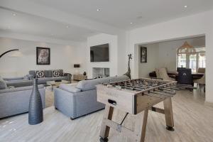 a living room with a foosball table in the middle at White House by the sea in Bournemouth +45 photos
