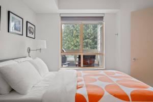 a bedroom with a bed and a large window at 1BR Stylish Condo central Village Location with Private Balcony in Whistler +34 photos