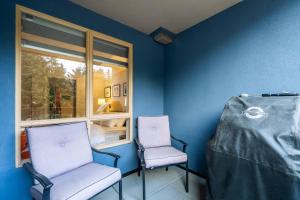 two chairs sitting in a room with a window at 1BR Stylish Condo central Village Location with Private Balcony in Whistler +6 photos